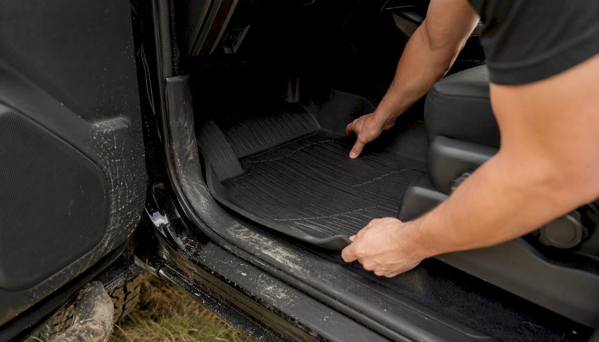 Hands installing custom Tacoma floor liner