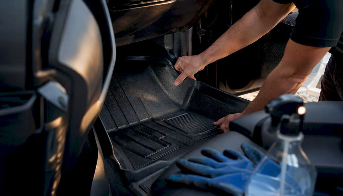 Hands fitting custom heavy-duty floor liner in vehicle