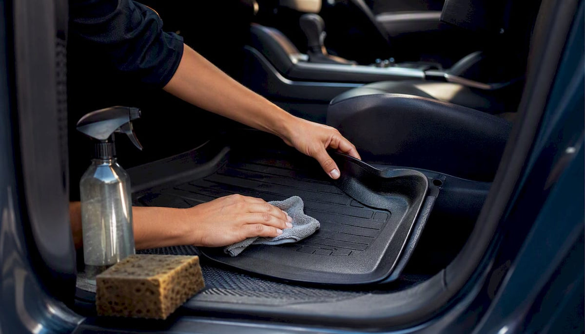 Hands cleaning custom car floor mat edge inside vehicle
