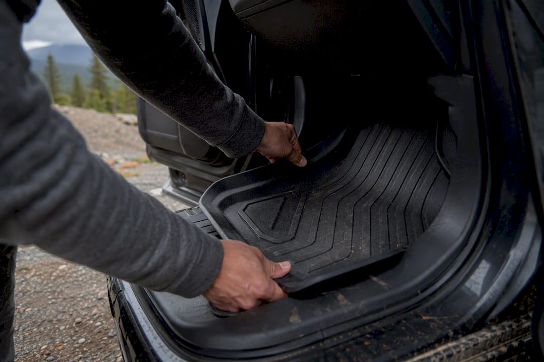 Hands fitting custom rubber car floor mat