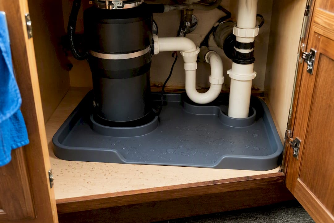 Silicone under sink mat trimmed around pipes