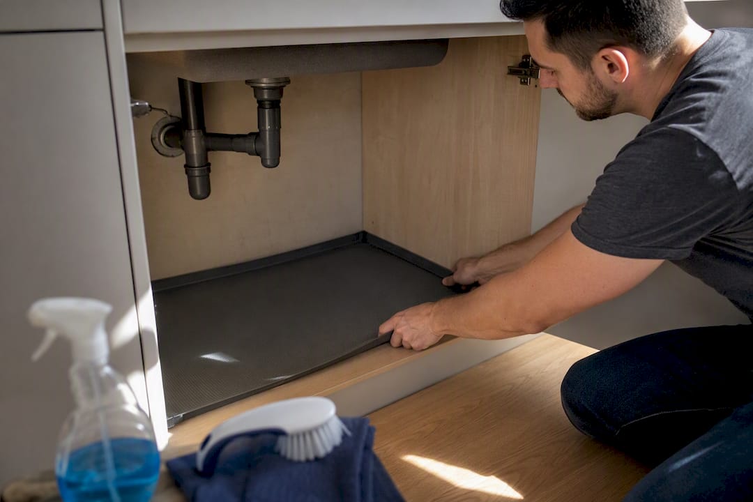 Hands fitting under-sink containment mat with lip