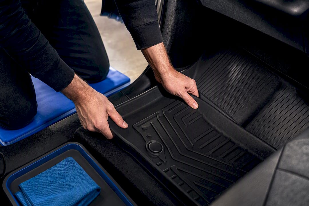 Hands pressing TPE liner into truck footwell