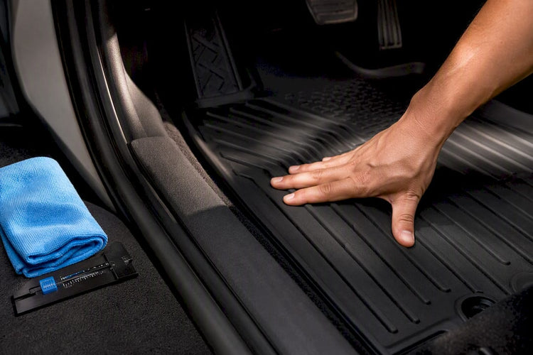 Hand checking floor liner fit near pedals