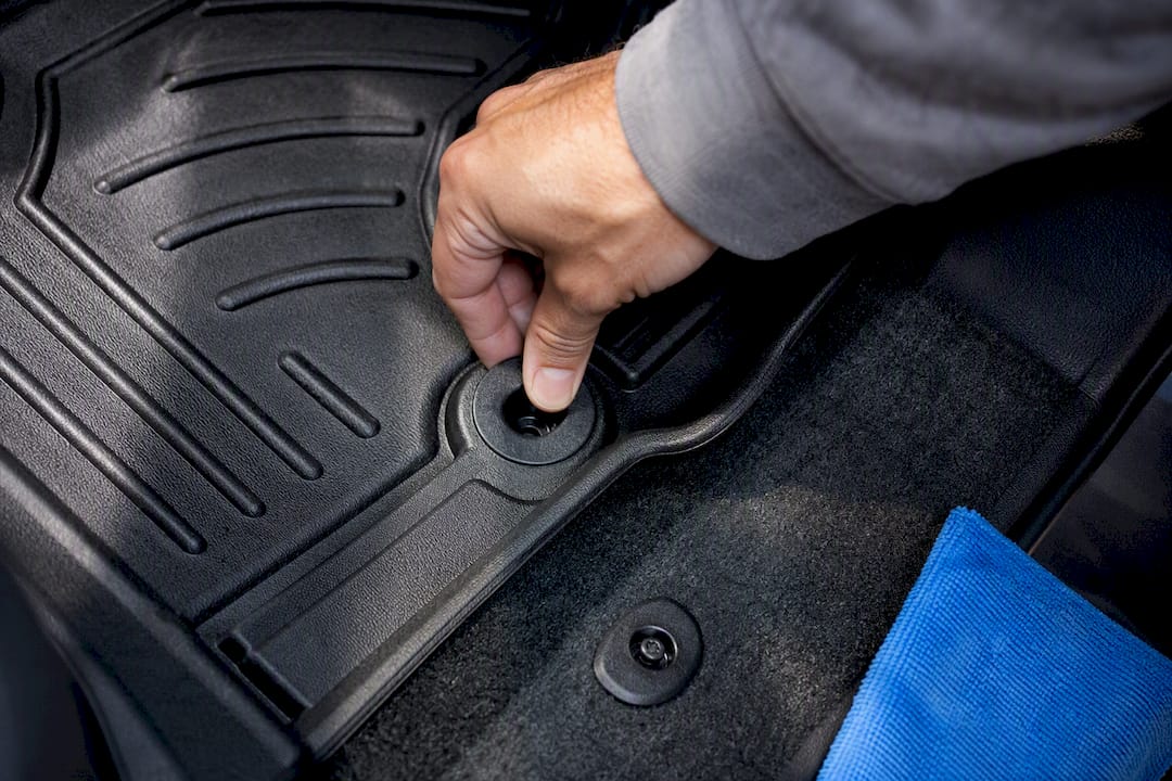 Hand checking floor mat anchor fit