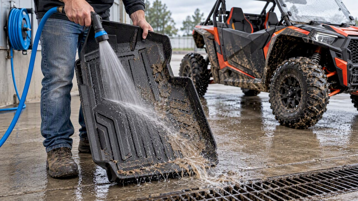 Muddy UTV liner being rinsed clean
