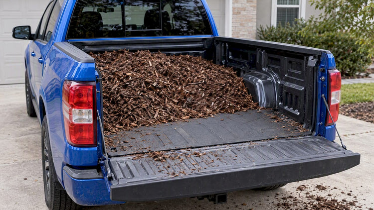 Pickup bed carrying mulch over a protective liner